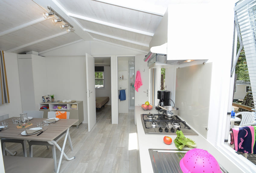 Kitchen opening on to the lounge area of static caravan Confort for 5 persons.  Static caravan rental in the Fayence area in 4 star Le Parc campsite.