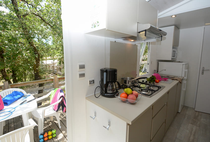 Kitchen and outside terrace of static caravan Confort for 5 persons.  Static caravan rental in the Fayence area in Le Parc campsite.
