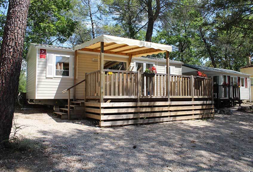 Gesamtansicht des Komfort-Wohnmobils  für 6 Personen und seiner Terrasse im Hinterland von Fréjus auf dem Campingplatz Le Parc.