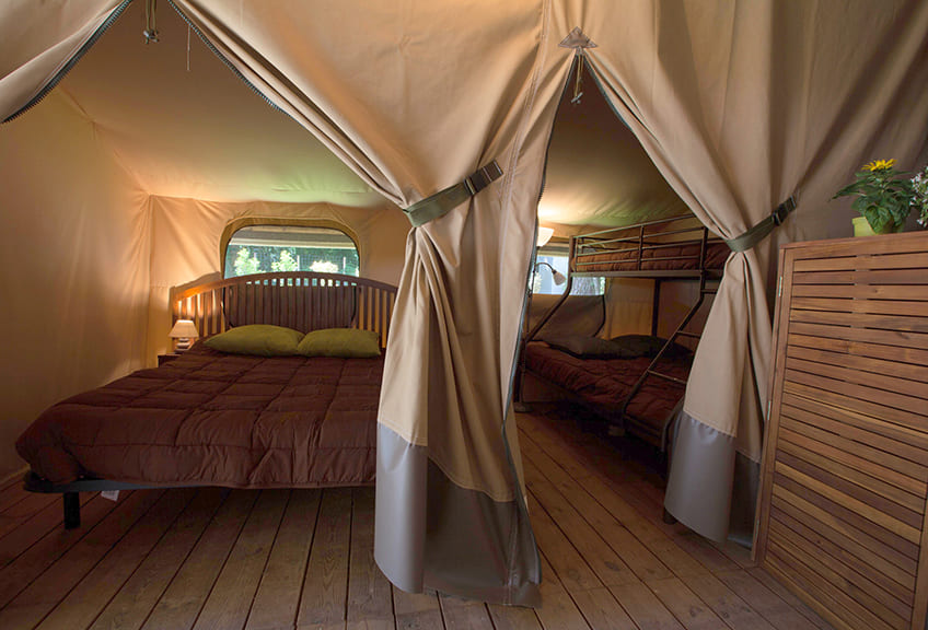 Slaapkamer met stapelbed en slaapkamer met tweepersoonsbed (140 cm). Safari Lodges in de Var op 4-sterren camping Le Parc.